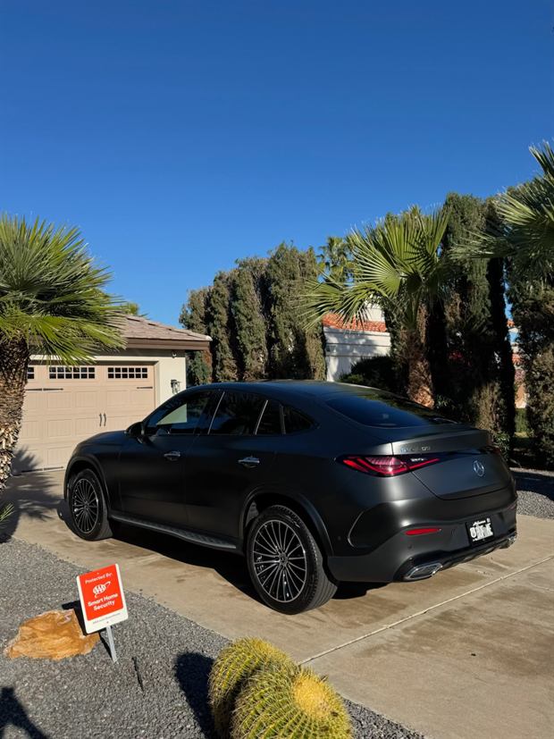 Black Mercedes-Benz coupe SUV washed, with palm trees behind