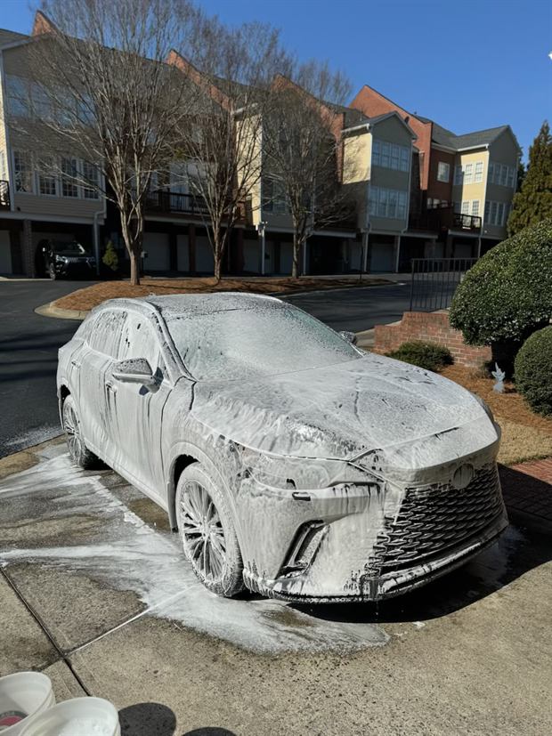 A Lexus RX under foam on a residential driveway